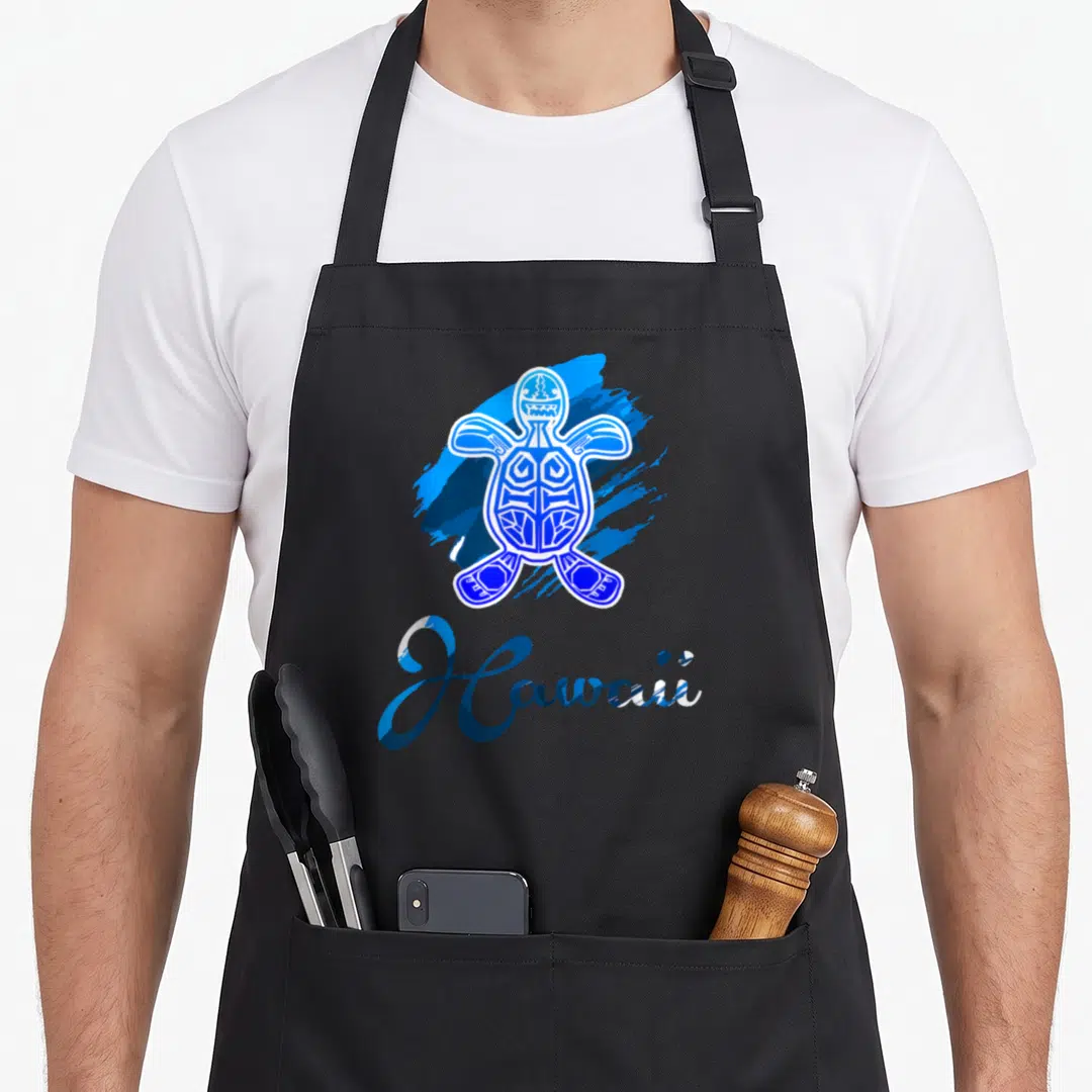 Blue tribal hawaiian apron - Blue and white cartoon tribal sea turtle over paint splash with Hawaii script text — shown on a black cotton canvas apron against a white background