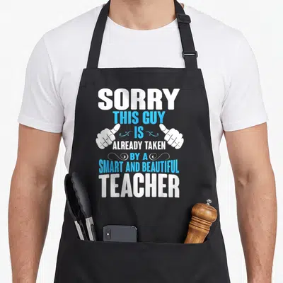 Taken teacher apron - Stacked white and cyan text with two pointing hands saying Sorry This Guy Is Already Taken — shown on a black cotton canvas apron against a white background