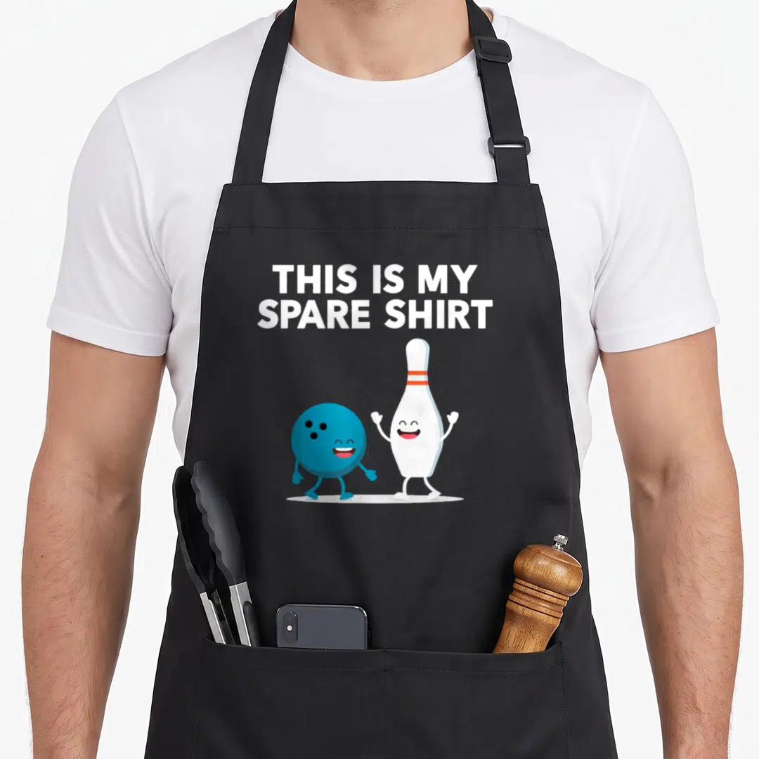Spare bowling apron - This Is My Spare Shirt text above blue ball and white pin with faces — shown on a black cotton canvas apron against a white background