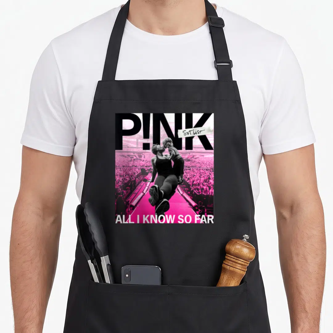 Far police girl apron - P!NK logo with woman holding child in pink stadium photo and all I know so far text — shown on a black cotton canvas apron against a white background
