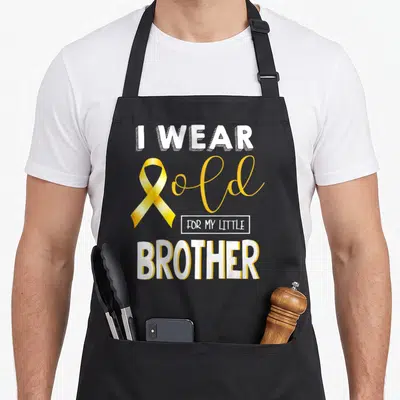 Brother childhood cancer awareness apron - Gold ribbon and white text reading I WEAR GOLD FOR MY LITTLE BROTHER — shown on a black cotton canvas apron against a white background