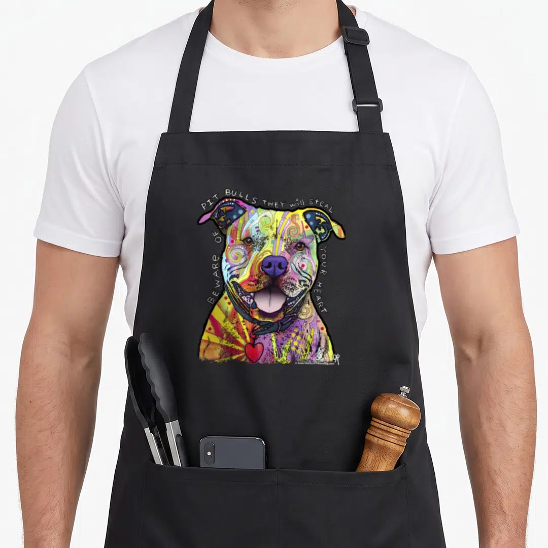 Beware dean russo aprons - Colorful cartoon pit bull with text 'Pit Bulls They Will Steal Beware Of Your Heart' and red — shown on a black cotton canvas apron against a white background