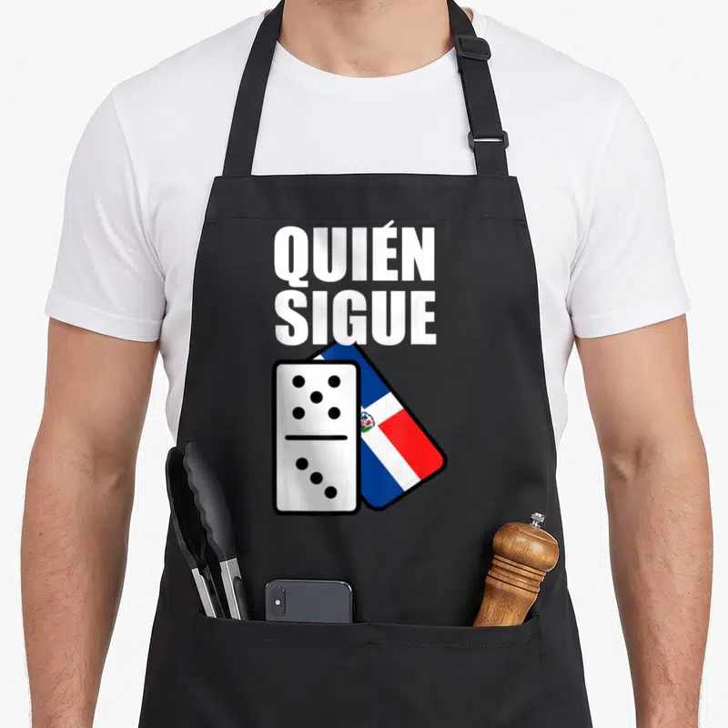 Dominican ralupop apron - Quien Sigue text above domino tile and Dominican Republic flag — shown on a black cotton canvas apron against a white background