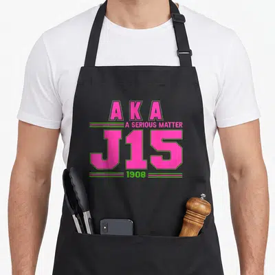 Serious aka apron - Pink and green AKA J15 1908 A Serious Matter typography design — shown on a black cotton canvas apron against a white background