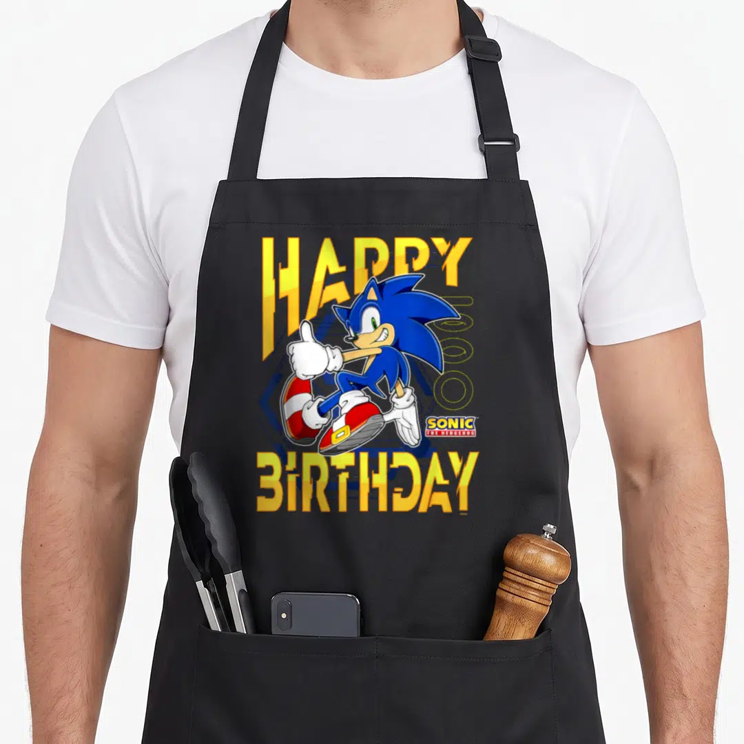 Thumb birthday apron - Sonic the Hedgehog giving thumbs up between yellow HAPPY BIRTHDAY text in blue and red — shown on a black cotton canvas apron against a white background