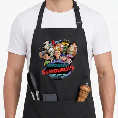 Dunham comedian apron - Neon Jeff Dunham Seriously Kansas City cartoon puppet cluster apron design — shown on a black cotton canvas apron against a white background
