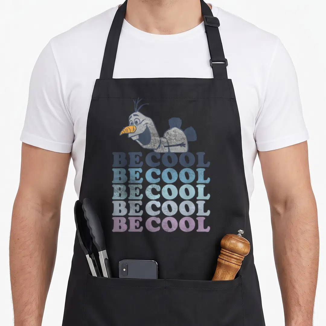 Olaf colorful apron - Cartoon snowman above five stacked BE COOL text lines in blue white and purple gradient — shown on a black cotton canvas apron against a white background