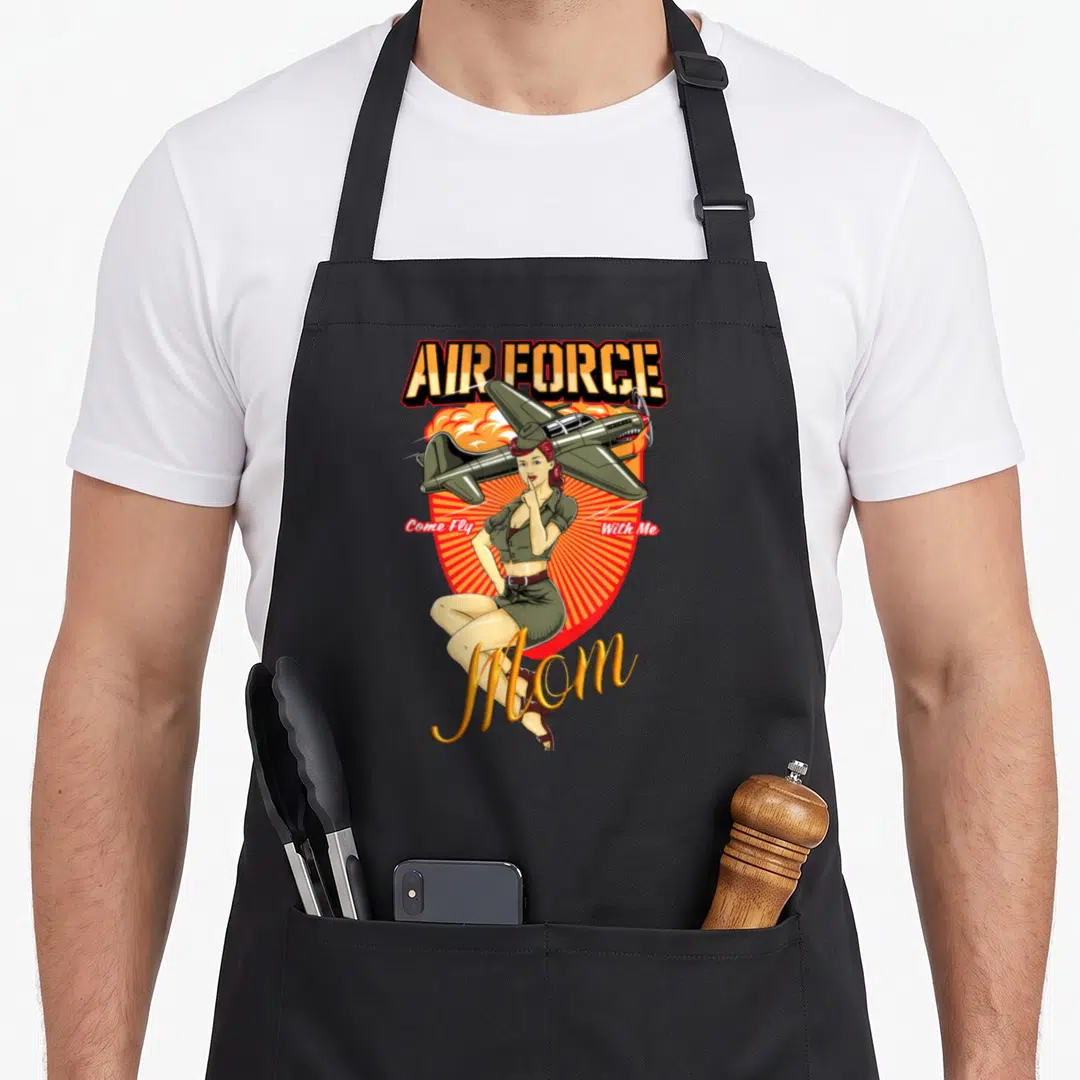 Service mother's day aprons - Retro woman in olive uniform sitting before red sunburst with AIR FORCE text and airplane — shown on a black cotton canvas apron against a white background