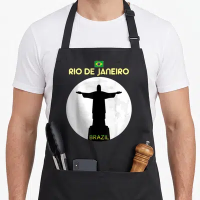 Rio brazilian apron - Black Christ the Redeemer silhouette in white circle under yellow Rio de Janeiro text and small — shown on a black cotton canvas apron against a white background