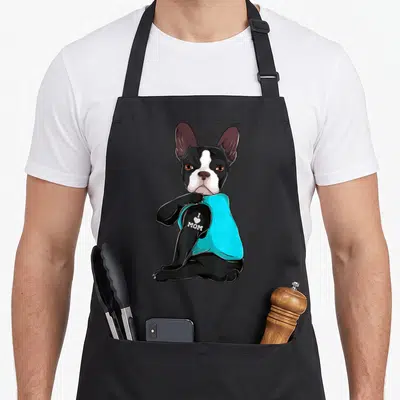 Boston terrier mom apron - Cartoon dog in cyan shirt with I Love Mom text on arm — shown on a black cotton canvas apron against a white background