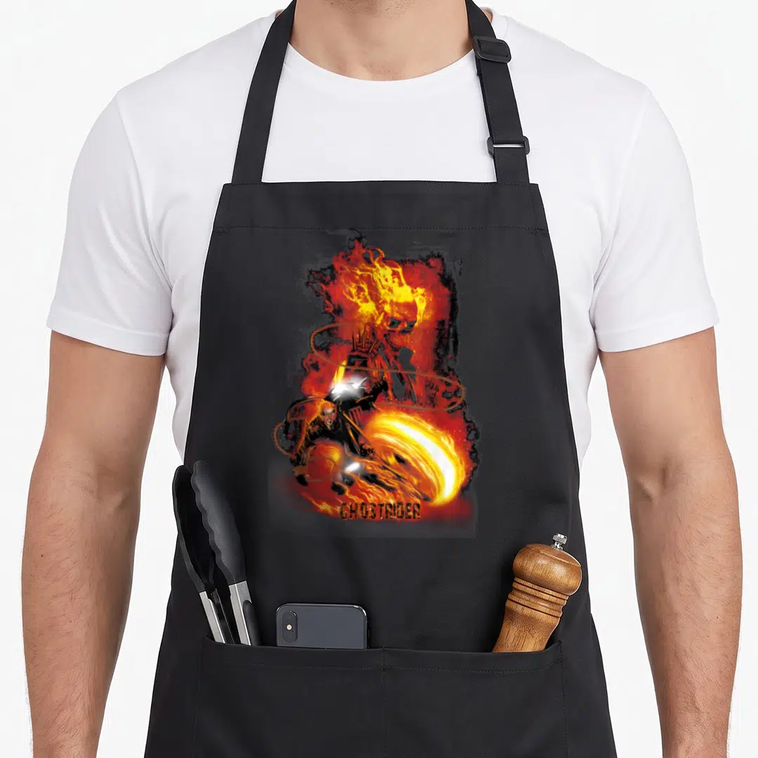 Fire ghost apron - GHOSTRIDER text below motorcyclist and flaming skull in orange, yellow, red, black — shown on a black cotton canvas apron against a white background
