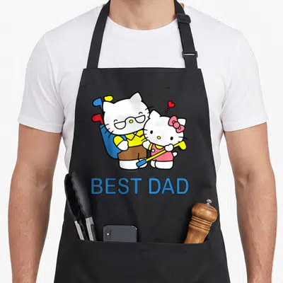 Hello father day apron - Two cartoon cats playing golf above blue BEST DAD text — shown on a black cotton canvas apron against a white background