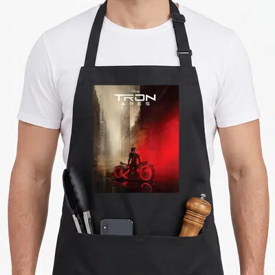 Tron movie poster apron - TRON ARES title text above person and light cycle in red grey city street scene — shown on a black cotton canvas apron against a white background