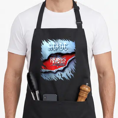Razor big band apron - Torn blue metal reveals red background with AC/DC The Razors Edge text — shown on a black cotton canvas apron against a white background
