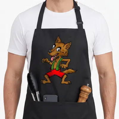 Three funny halloween aprons - Cartoon brown wolf wearing red shorts and green suspenders standing centrally — shown on a black cotton canvas apron against a white background