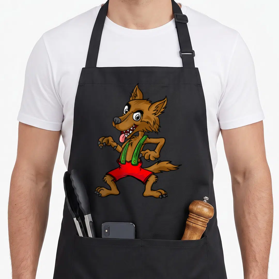 Three funny halloween aprons - Cartoon brown wolf wearing red shorts and green suspenders standing centrally — shown on a black cotton canvas apron against a white background