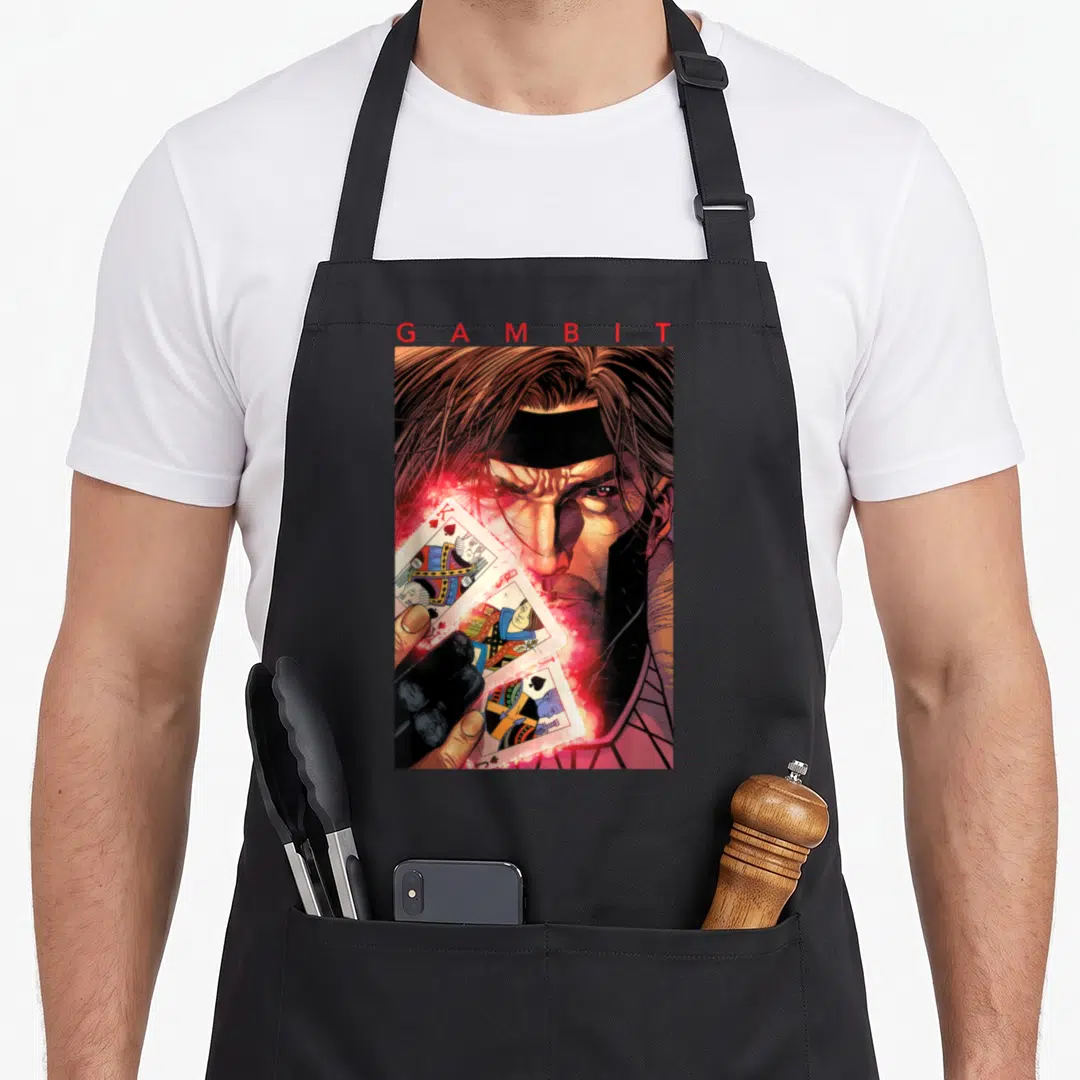 Gambit x apron - Realistic portrait of Gambit holding three glowing playing cards with red text — shown on a black cotton canvas apron against a white background