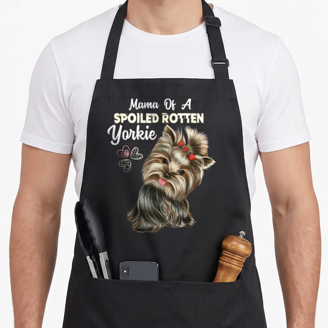 Retro dog yorkie apron - Realistic Yorkie with red bow and hearts below stacked text Mama Of A Spoiled Rotten Yorkie — shown on a black cotton canvas apron against a white background