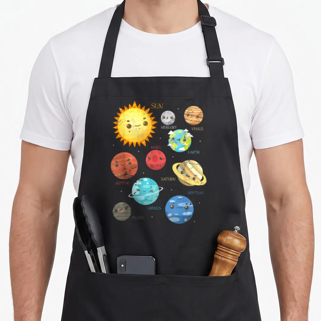 Planet astronomy life apron - Cartoon solar system with labeled Sun, Mercury, Venus, Earth, Mars, Jupiter, Saturn — shown on a black cotton canvas apron against a white background