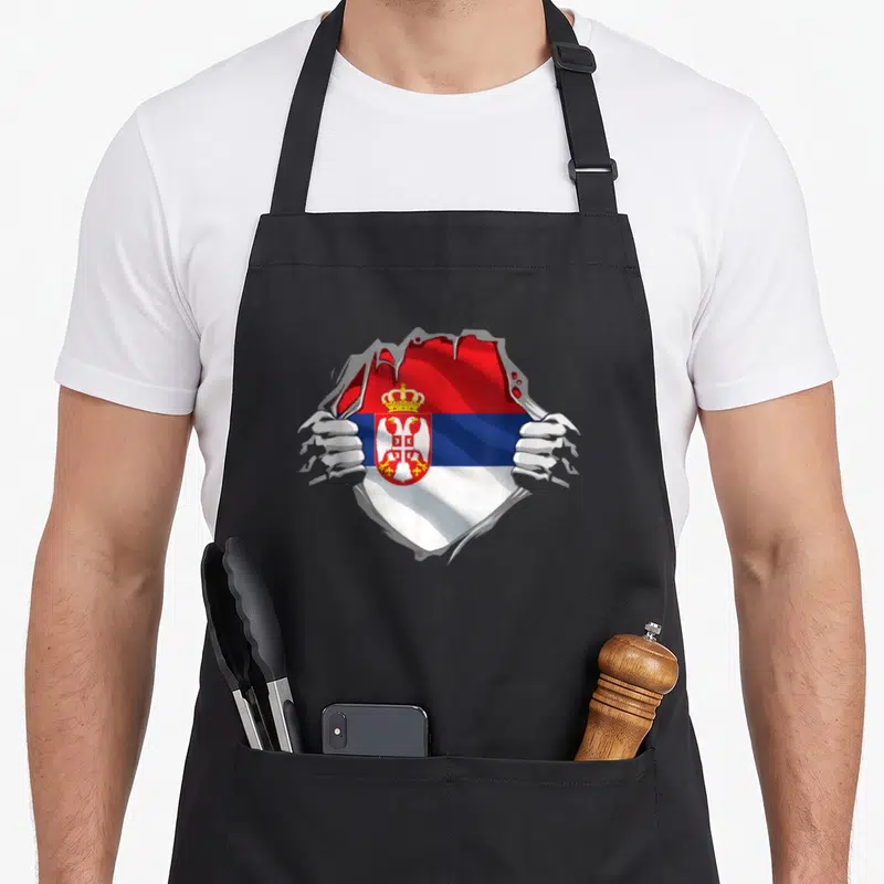 Serbian croatian girl apron - Two hands tearing grey surface to reveal red blue white Serbian flag with coat of arms — shown on a black cotton canvas apron against a white background