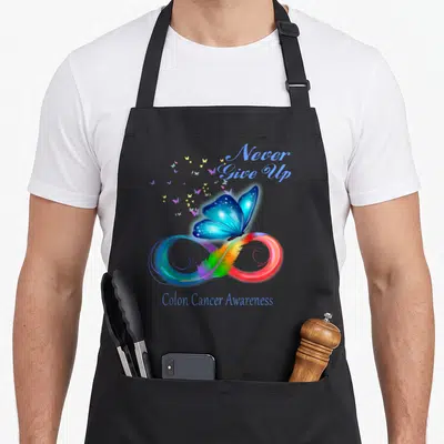 Cancer butterfly apron - Blue butterfly on rainbow feather infinity symbol with Never Give Up text — shown on a black cotton canvas apron against a white background