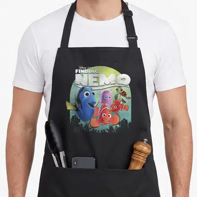 Shot navy officially apron - Disney Pixar Finding Nemo text above blue fish, orange clownfish, purple octopus — shown on a black cotton canvas apron against a white background