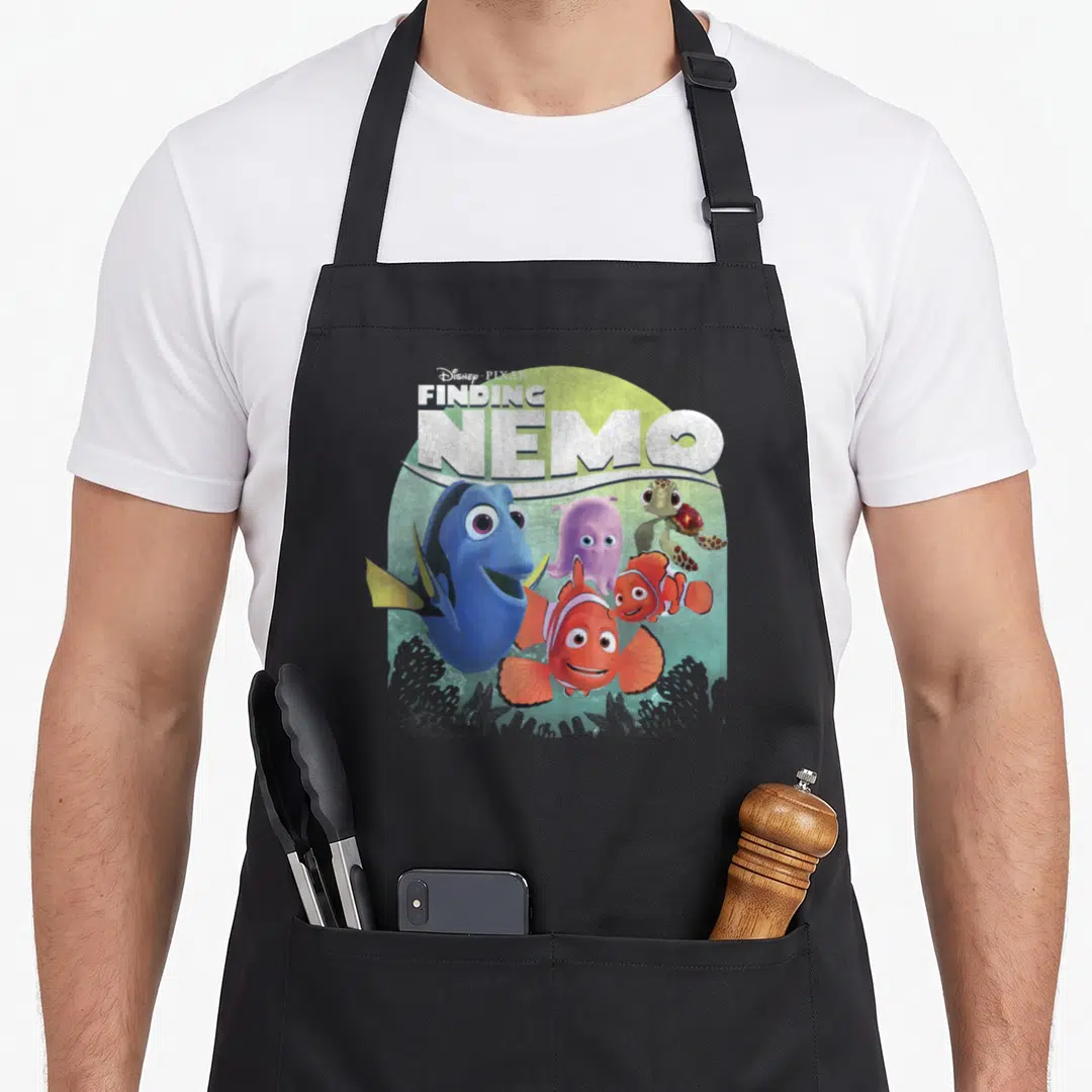 Shot navy officially apron - Disney Pixar Finding Nemo text above blue fish, orange clownfish, purple octopus — shown on a black cotton canvas apron against a white background
