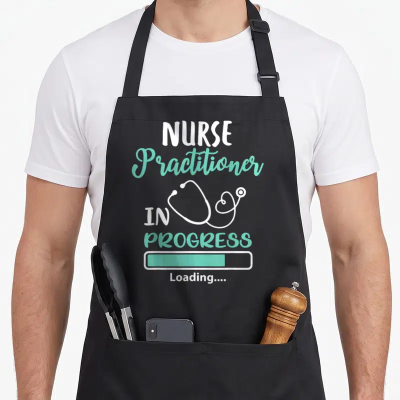 Practitioner nursing apron - Nurse Practitioner In Progress Loading text with white stethoscope and mint green progress — shown on a black cotton canvas apron against a white background