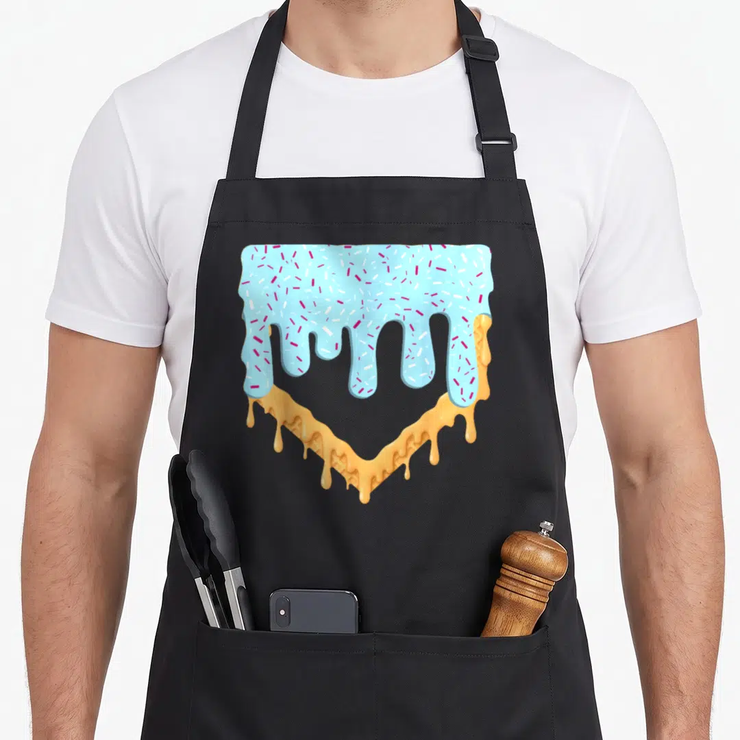 Drip youth ice cream apron - Cartoon waffle heart with dripping blue frosting and pink white sprinkles — shown on a black cotton canvas apron against a white background