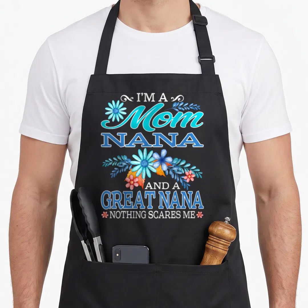 Scare nana aprons - Vertical text I'M A Mom NANA AND A GREAT NANA NOTHING SCARES ME with blue and red floral — shown on a black cotton canvas apron against a white background