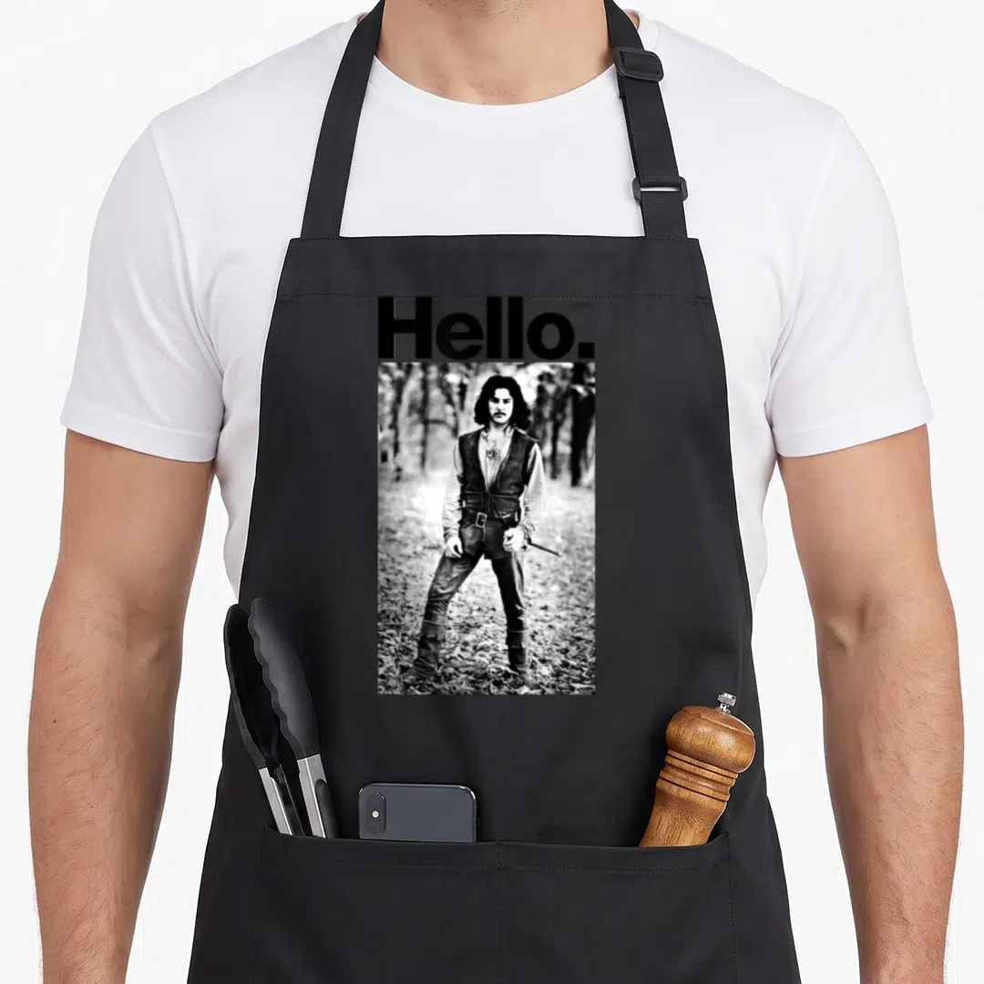 Bride inigo princess apron - Hello text above black and white photo of man standing in forest — shown on a black cotton canvas apron against a white background