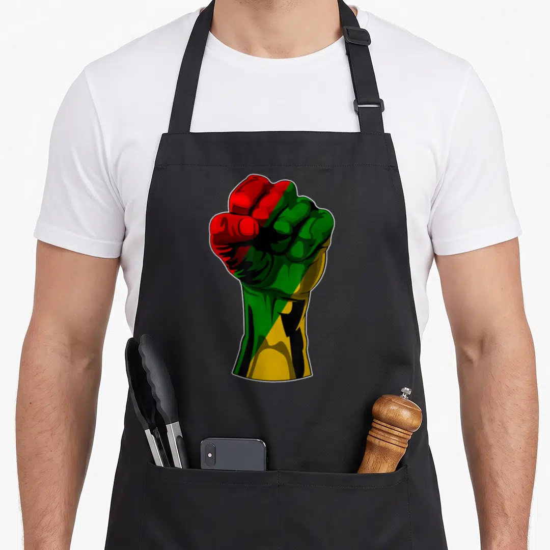History kwanzaa apron - Cartoon clenched fist filled with red, black, green, and yellow colors — shown on a black cotton canvas apron against a white background