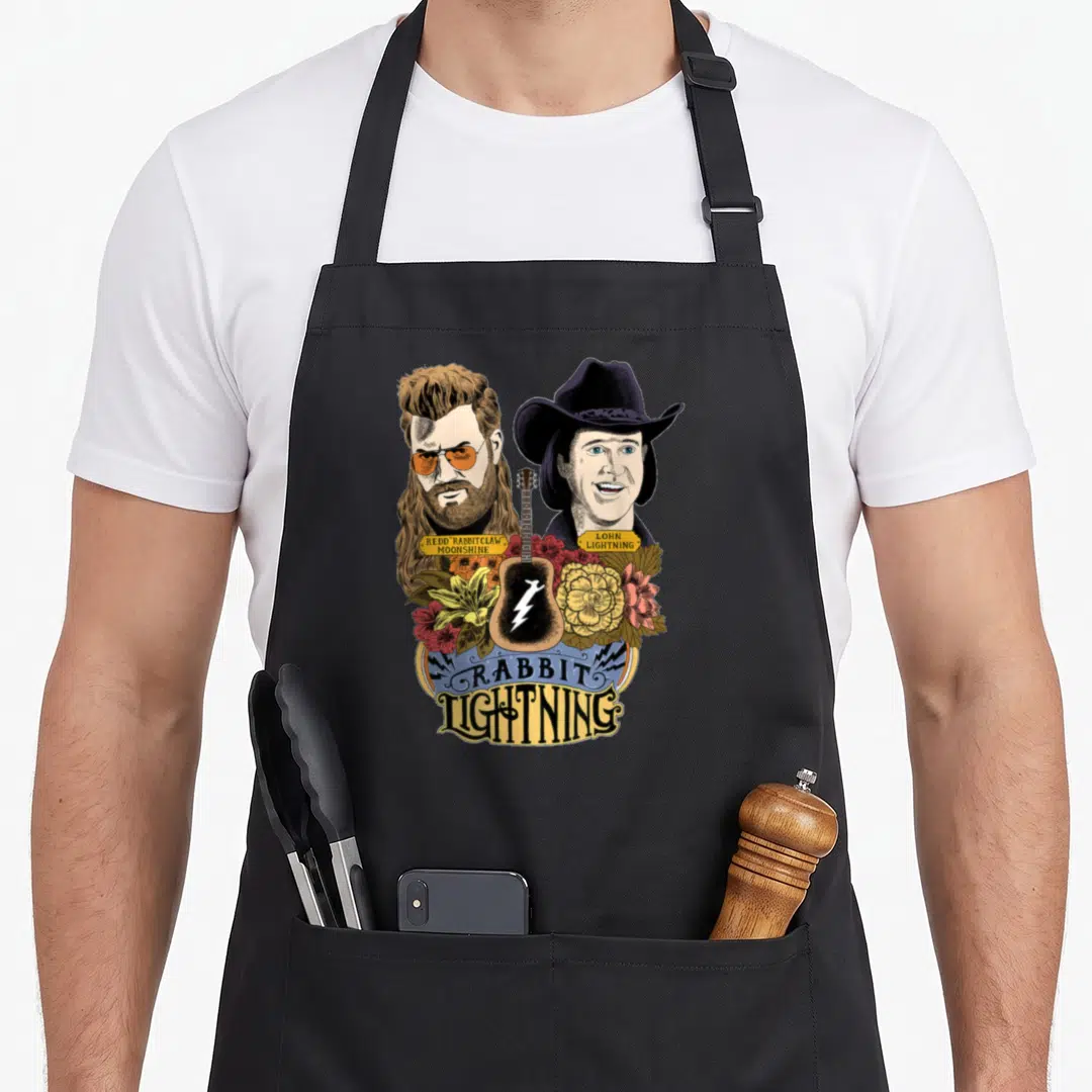 Mythical rabbit apron - Cartoon portraits of two men flanking a guitar with Rabbit Lightning text and yellow brown red — shown on a black cotton canvas apron against a white background