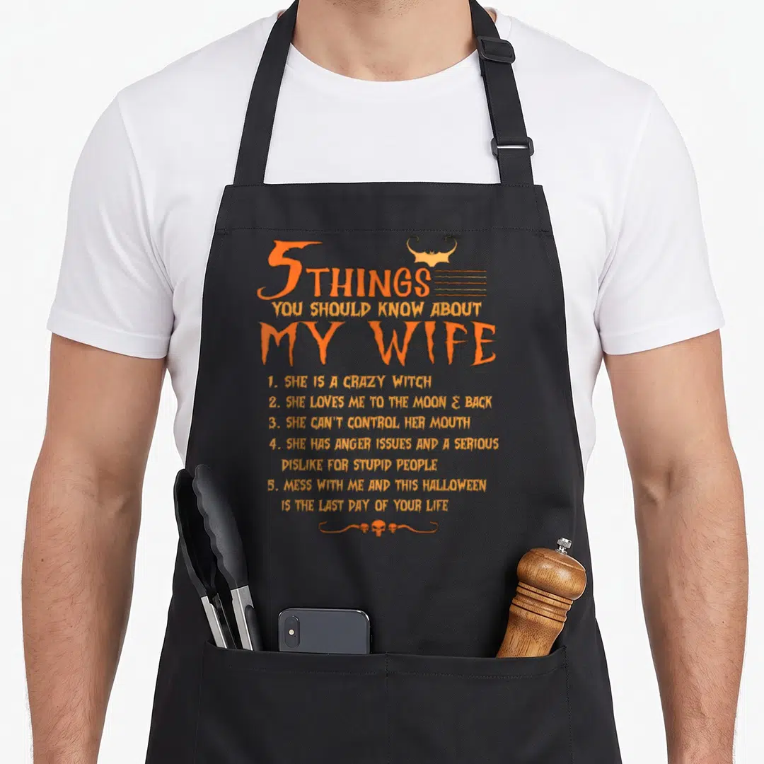 Should witch apron - Orange text 5 things you should know about my wife with bat and skull graphics — shown on a black cotton canvas apron against a white background