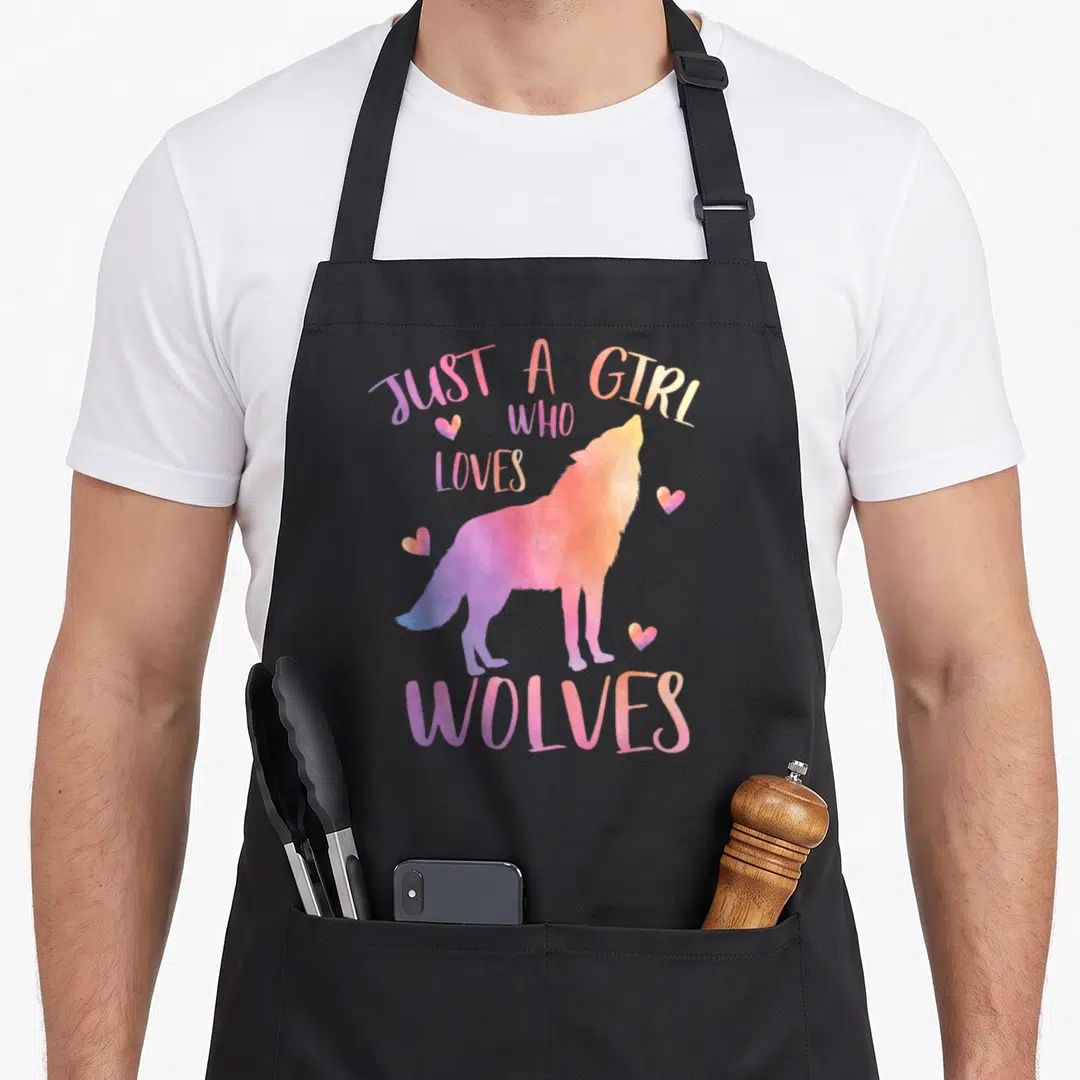 Funny watercolor wolves apron - Purple pink orange watercolor wolf howling with Just a Girl Who Loves Wolves text — shown on a black cotton canvas apron against a white background