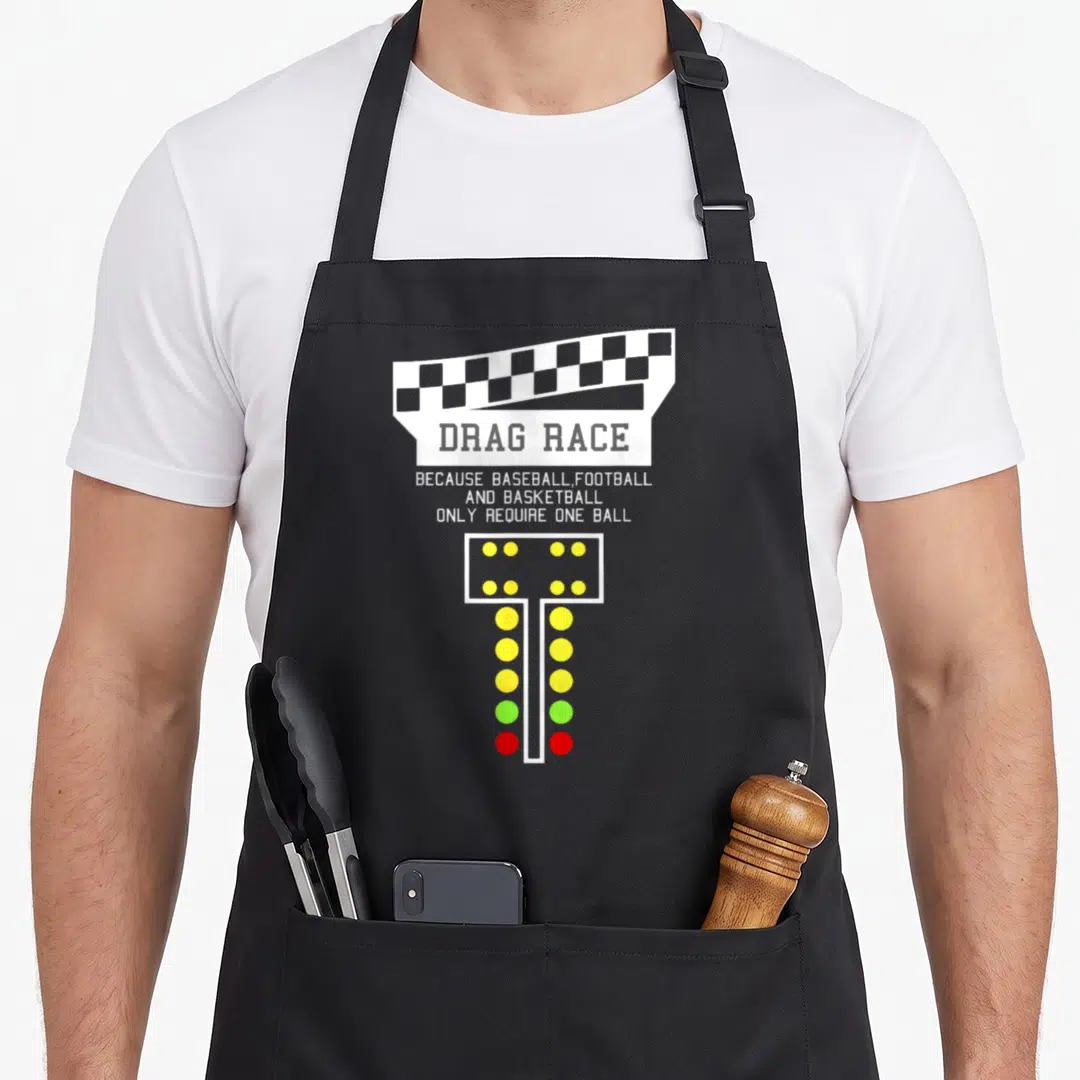 Drag christmas apron - Checkered flag, drag race text, and vertical light tree with yellow green and red lights — shown on a black cotton canvas apron against a white background