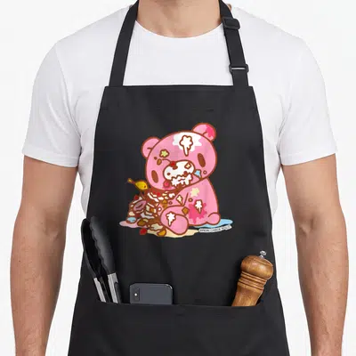Grizzly halloween apron - Pink cartoon bear sitting with messy cake and food splatters in anime style — shown on a black cotton canvas apron against a white background