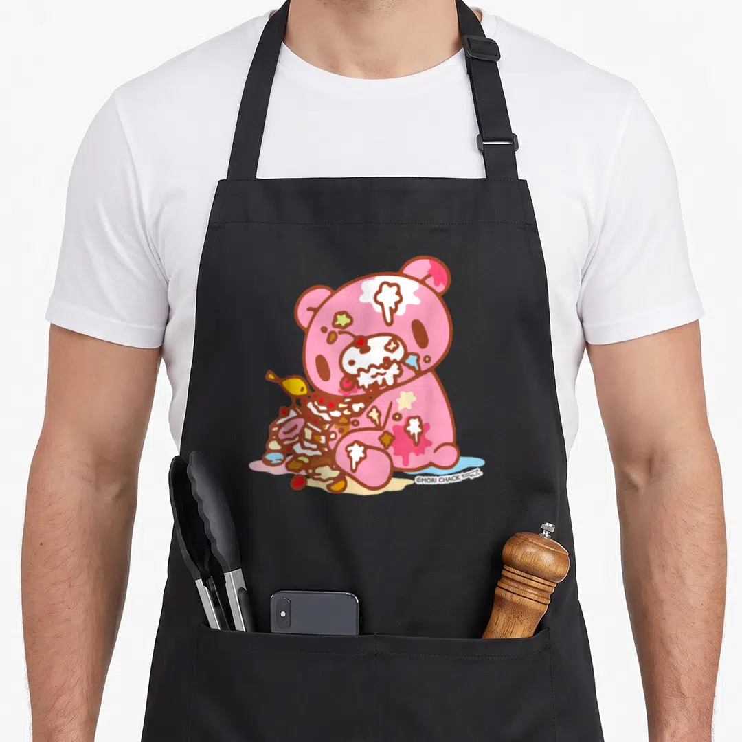 Grizzly halloween apron - Pink cartoon bear sitting with messy cake and food splatters in anime style — shown on a black cotton canvas apron against a white background