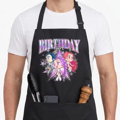 Adorable birthday apron - Three anime girls in front of a purple star under BIRTHDAY girl text in cartoon style — shown on a black cotton canvas apron against a white background