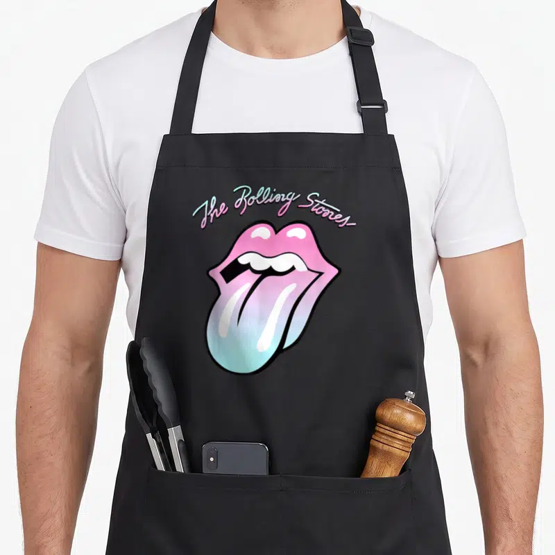 Gradient rolling stones apron - Arched text above pink and blue gradient cartoon mouth with protruding tongue — shown on a black cotton canvas apron against a white background