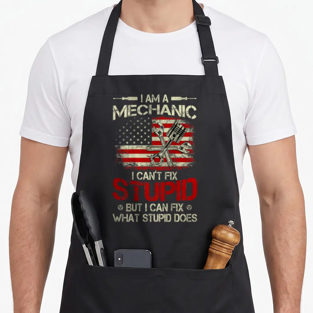 Fix american flag apron - Crossed wrenches piston and screwdrivers over distressed US flag with mechanic quote — shown on a black cotton canvas apron against a white background