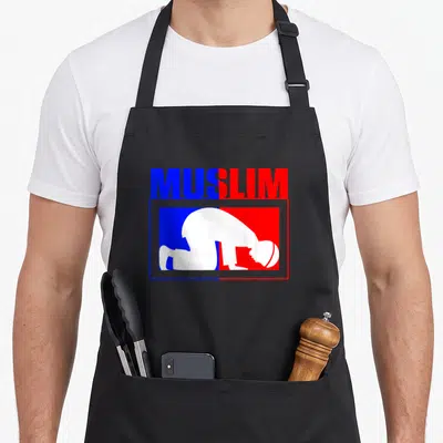 Islam ramadan apron - MUSLIM text split blue red above white praying silhouette in rectangular frame — shown on a black cotton canvas apron against a white background