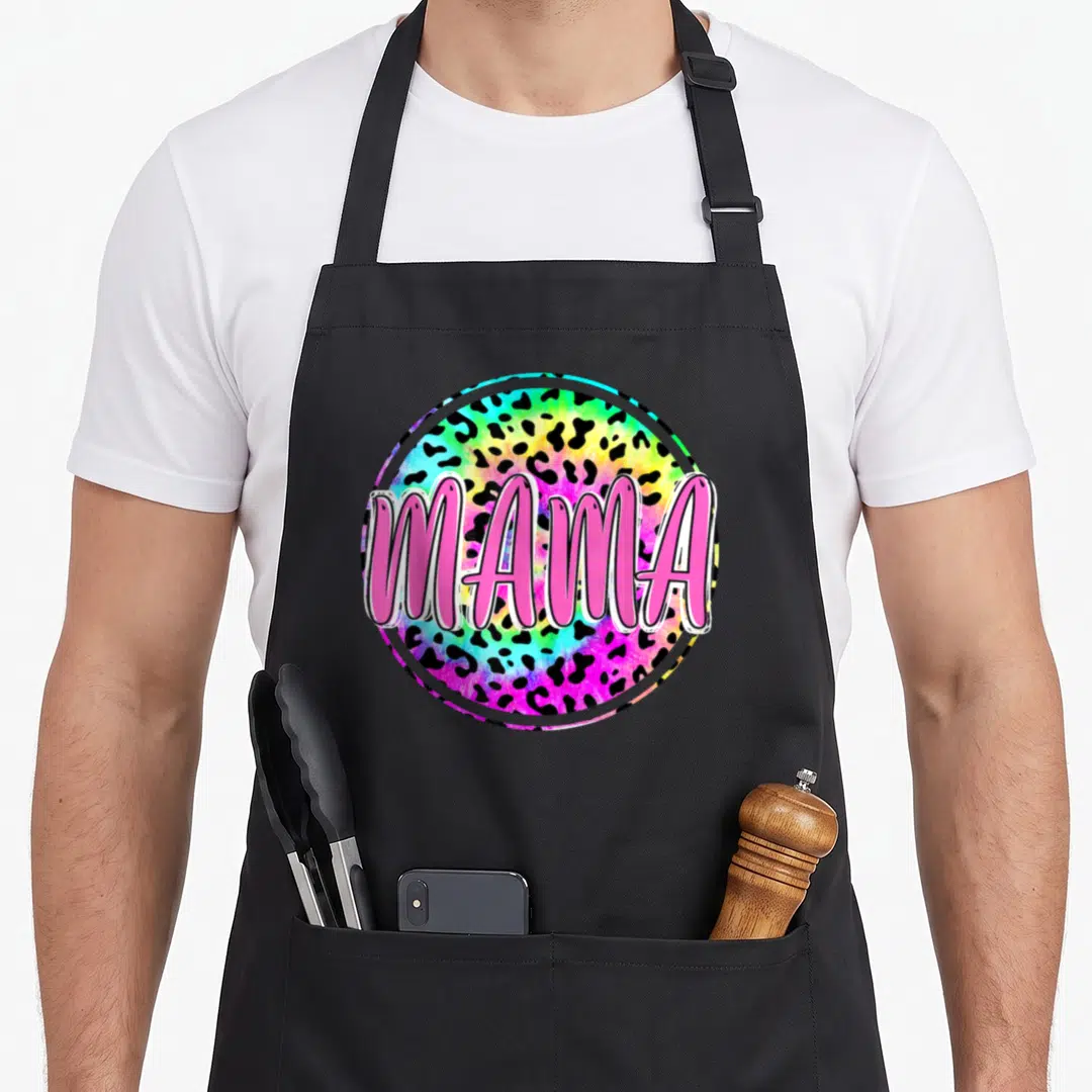 Tie leopard print cooking apron - MAMA pink text on circular rainbow leopard print background — shown on a black cotton canvas apron against a white background
