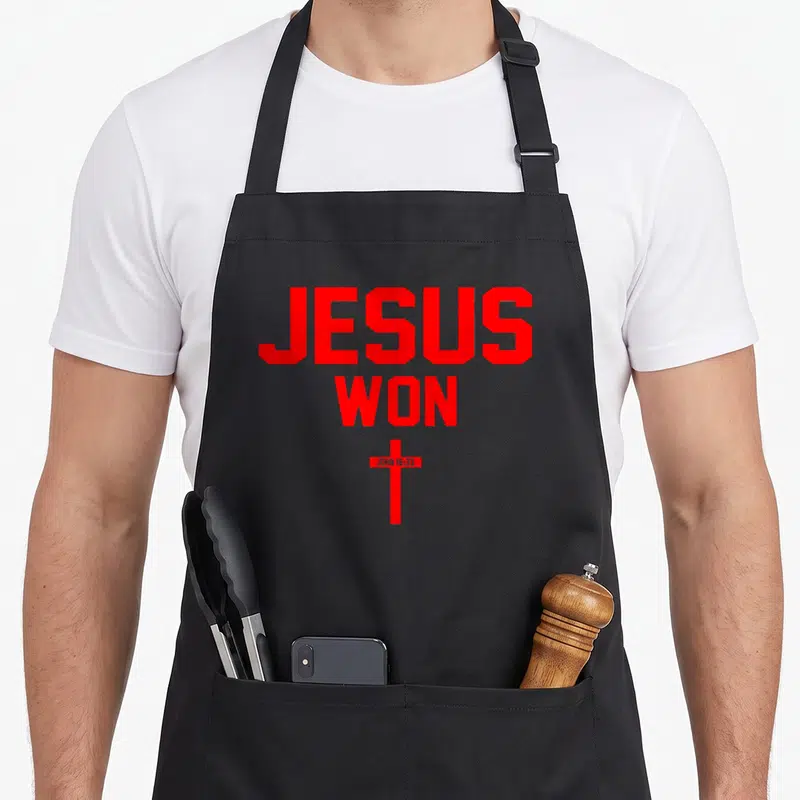Won christian apron - Red JESUS WON text above cross with JOHN 16:33 on bar — shown on a black cotton canvas apron against a white background