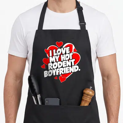 Rodent i love my rat apron - Bold white text reading I LOVE MY HOT RODENT BOYFRIEND over a large red heart surrounded — shown on a black cotton canvas apron against a white background