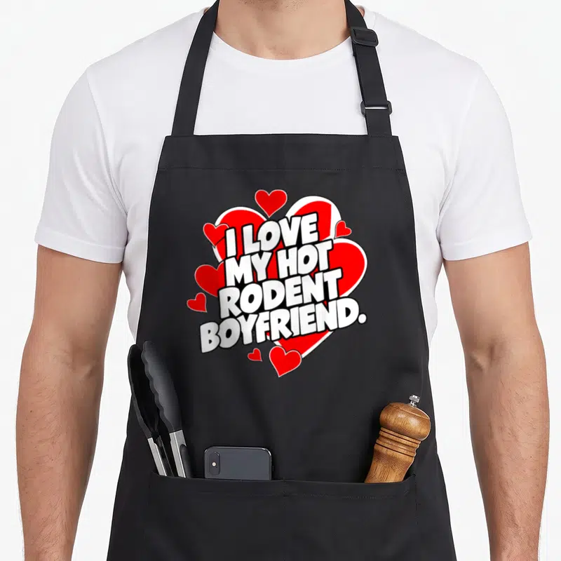 Rodent i love my rat apron - Bold white text reading I LOVE MY HOT RODENT BOYFRIEND over a large red heart surrounded — shown on a black cotton canvas apron against a white background