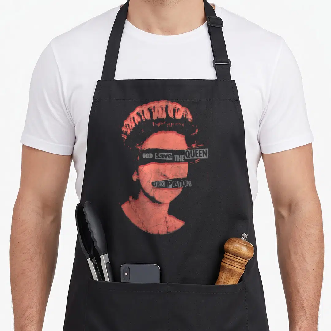 Pistol queen apron - Red halftone portrait with GOD SAVE THE QUEEN across eyes and SEX PISTOLS across mouth — shown on a black cotton canvas apron against a white background