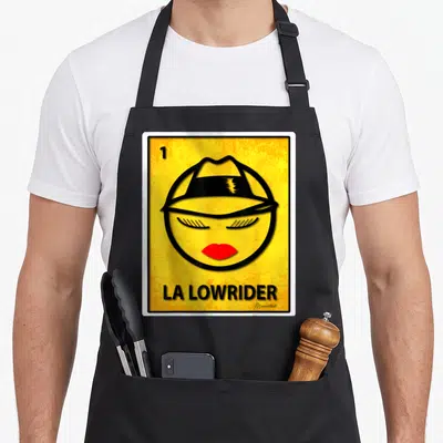 Funny lowrider apron - Stylized face with hat and red lips on yellow background with LA Lowrider text — shown on a black cotton canvas apron against a white background