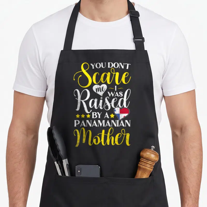Souvenir panamanian girl apron - Stacked text YOU DON'T Scare me I WAS Raised BY A PANAMANIAN Mother with flag heart — shown on a black cotton canvas apron against a white background