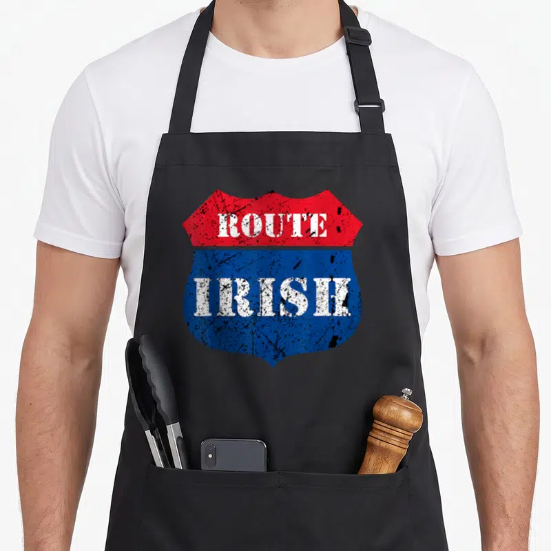 Route irish aprons - Red and blue shield sign with distressed white ROUTE IRISH text — shown on a black cotton canvas apron against a white background